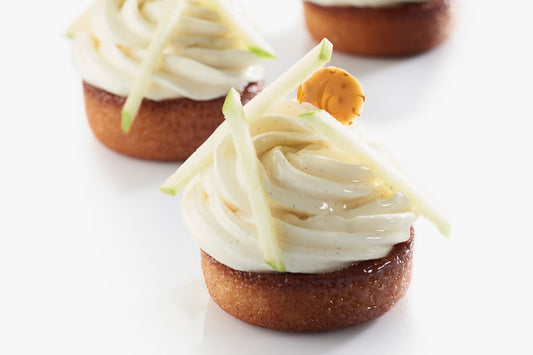 Mini apple tatin-style financiers filled with caramelized apples and topped with Ivoire 35% & apple whipped ganache