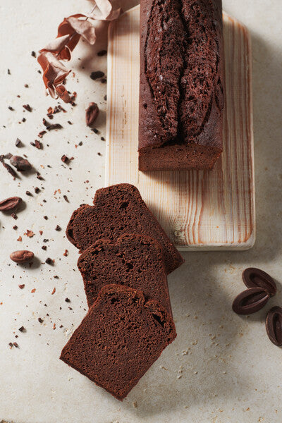 Gluten-free dark chocolate cake on a wooden board and cut in slices