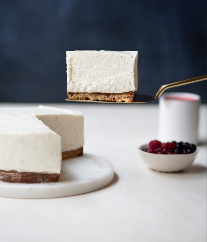 Vanilla cheesecake served on a tray with a slice on a pie server