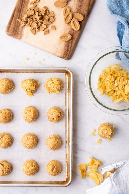 Caramelized white chocolate and potato chip cookies placed on a rack and ready to be baked