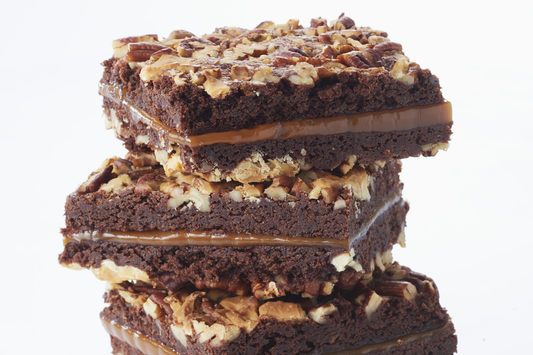 Dark chocolate caramel brownies cut in squares and stacked on top of each other