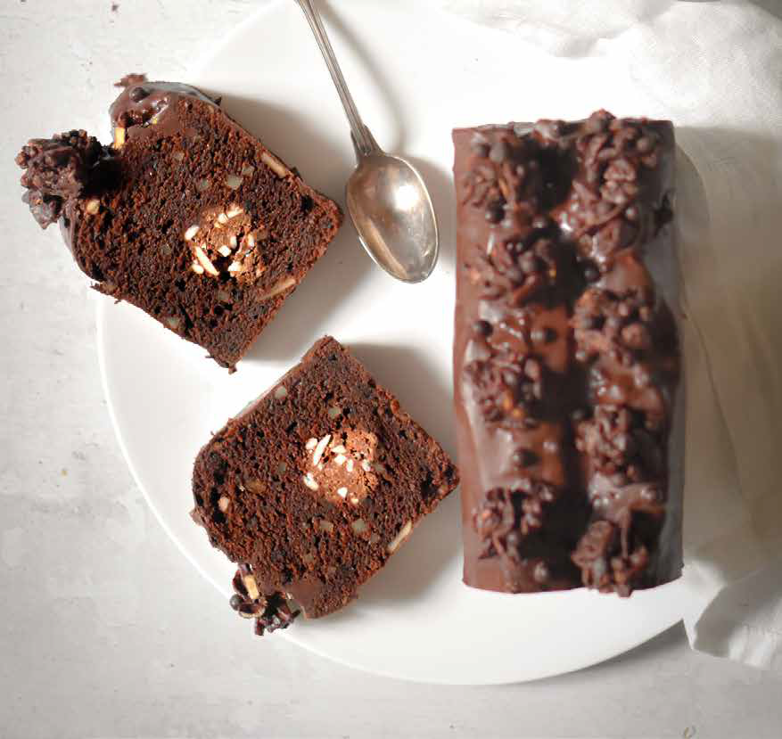 Dark chocolate cake with almond crisp filling, cereal clusters and dark chocolate glaze with cut slices