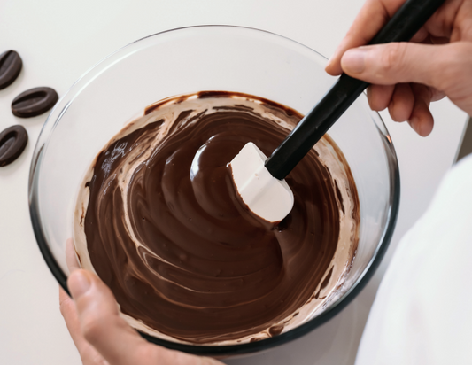 Gesture tempering dark melted chocolate in a bowl