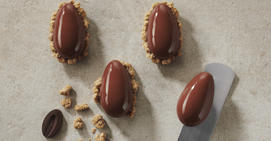 Dark Chocolate Hearts of Ice placed on a surface with a chocolate bean and a spatula