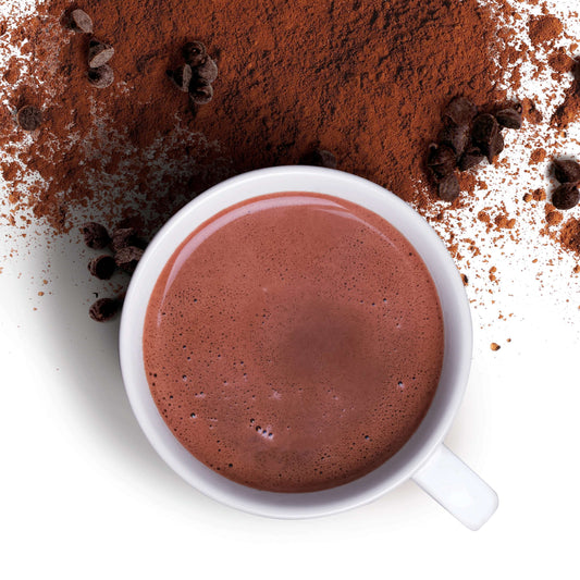 Classic hot chocolate with Guanaja 70% and cocoa powder served in a mug and surrounded by cocoa powder