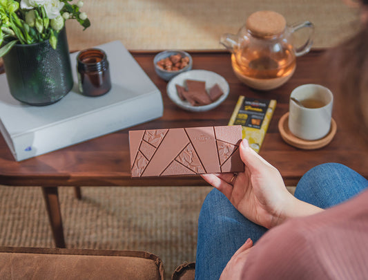 Lifestyle image of a woman enjoying a chocolate bar during a tea time