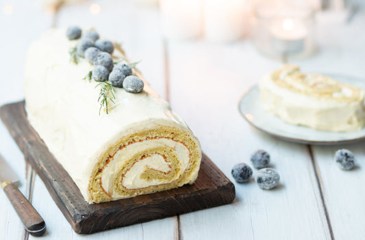 Yule log with vanilla cream filling ready to serve and cut with a slice in a plate