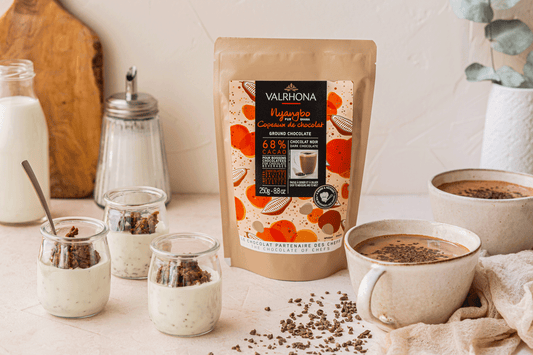 Nyangbo Ground Chocolate 68% on a kitchen counter with desserts around