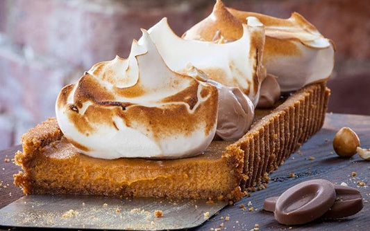 Milk chocolate pumpkin pie with whipped ganache cut and ready to serve