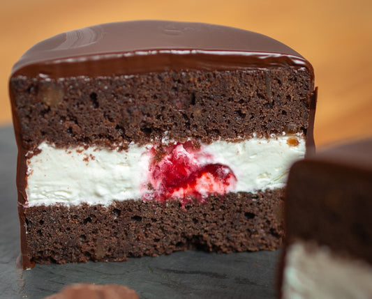 Dark chocolate ring dings with vanilla and raspberry cream filling cut in half