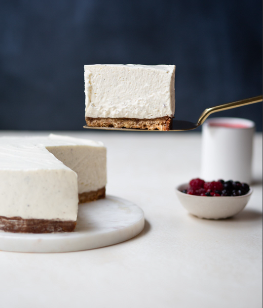 Vanilla cheesecake served on a tray with a slice on a pie server