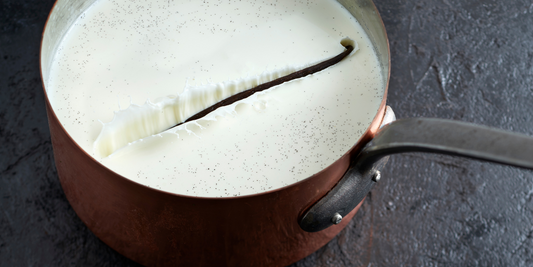 Vanilla pod infusing milk inside a saucepan