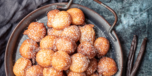 Zoom on vanilla beignets ready to be served next to vanilla beans