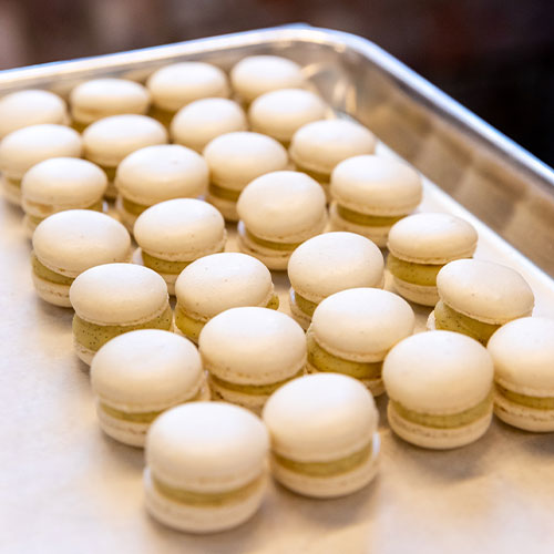 White chocolate and vanilla macarons laid down on a plate and ready to be served