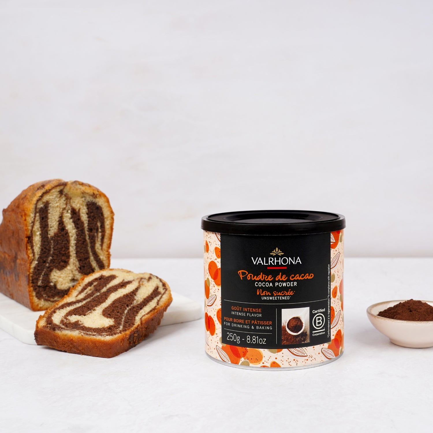 Valrhona cocoa powder container with a sliced zebra-patterned cake
