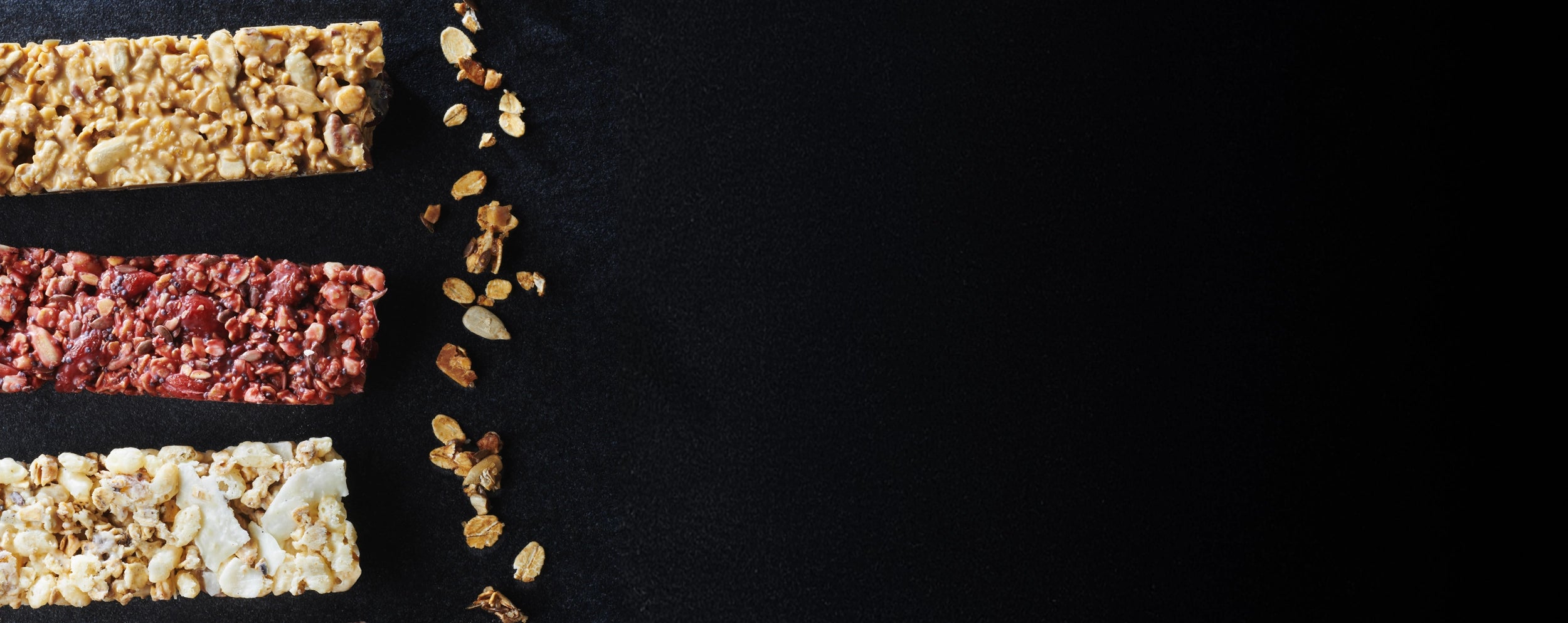 Four different types of cereal bars on a black background